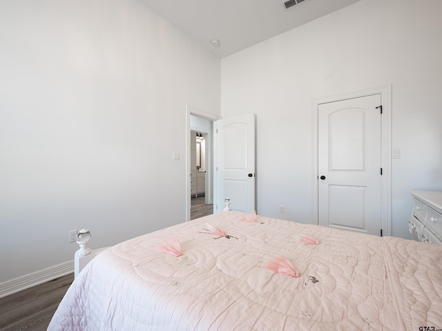 bedroom featuring visible vents, wood finished floors, and baseboards