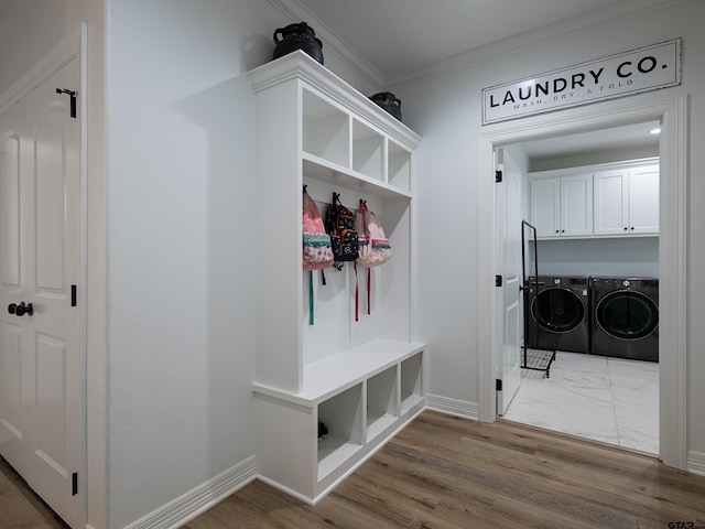 mudroom featuring crown molding, wood finished floors, separate washer and dryer, and baseboards