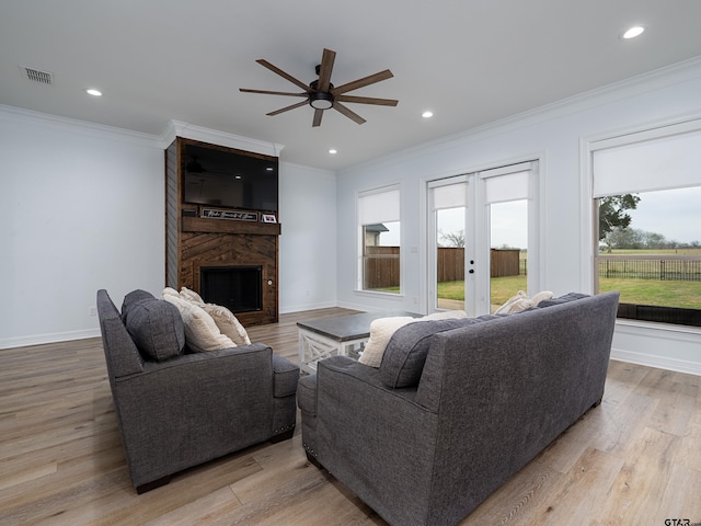 living room featuring a ceiling fan, crown molding, and a healthy amount of sunlight