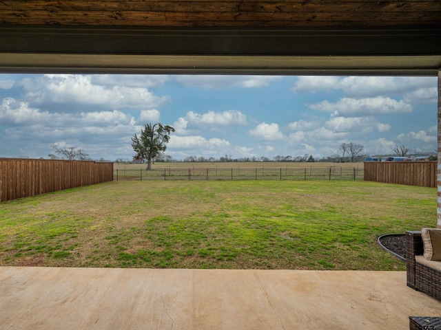 view of yard with a patio, a rural view, and a fenced backyard