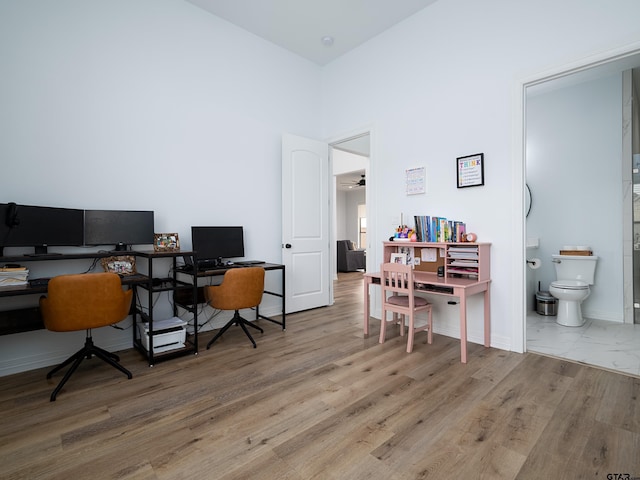 office with a high ceiling, wood finished floors, and baseboards