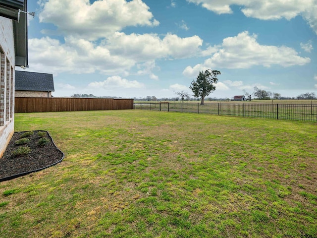 view of yard featuring a rural view and fence