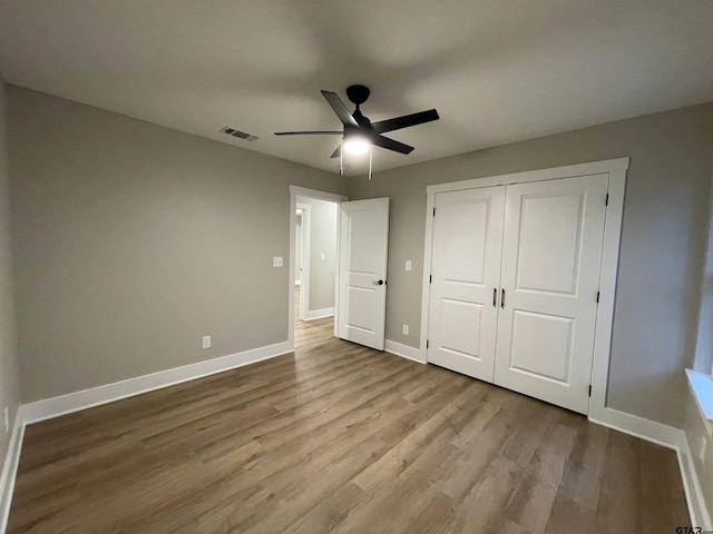 unfurnished bedroom with ceiling fan, light hardwood / wood-style floors, and a closet