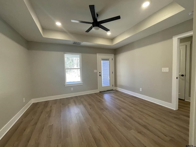 spare room with a raised ceiling and hardwood / wood-style flooring