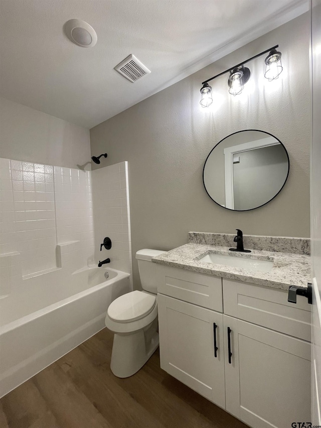 full bathroom with hardwood / wood-style floors, vanity,  shower combination, and toilet