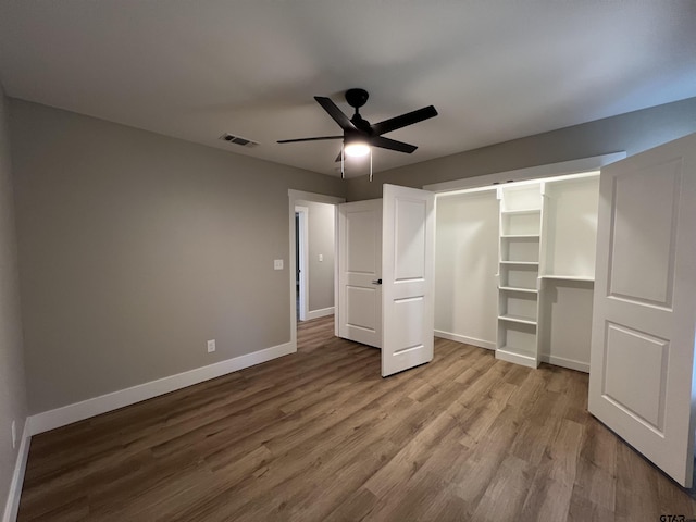 unfurnished bedroom featuring ceiling fan, wood-type flooring, and a closet