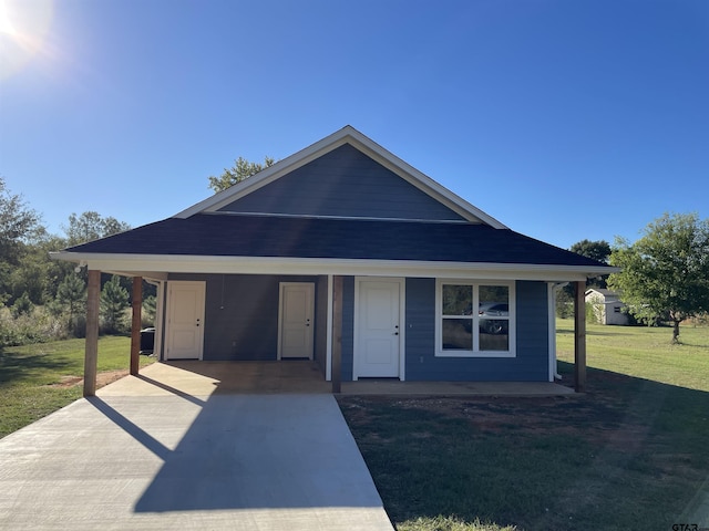 view of front of house with a front lawn and a carport