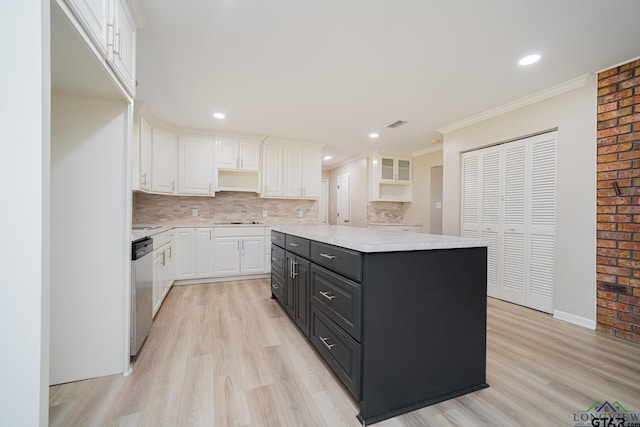 kitchen with white cabinetry, stainless steel dishwasher, and a kitchen island