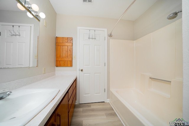 bathroom with vanity, hardwood / wood-style flooring, and shower / bath combination