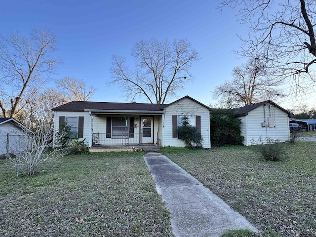 ranch-style home featuring covered porch and a front yard