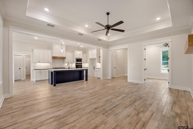 14738 Woodland Creek Dr, Tyler, TX 75706 - kitchen with a ceiling fan, a tray ceiling, oven, a sink, and light wood-style floors