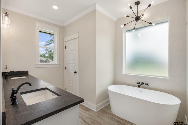 14738 Woodland Creek Dr, Tyler, TX 75706 - bathroom with a freestanding tub, wood finished floors, double vanity, ornamental molding, and baseboards
