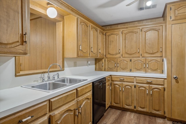 kitchen with wood finished floors, ceiling fan, a sink, light countertops, and black dishwasher