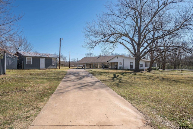 view of front of property featuring concrete driveway and a front yard