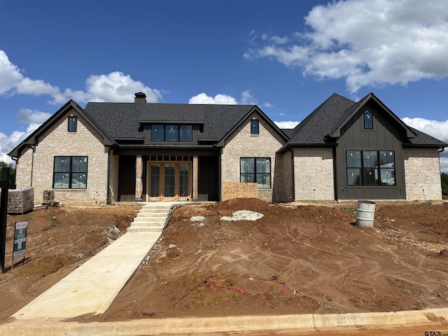 20253 Roebuck Dr, Bullard, TX 75757 - modern farmhouse style home featuring brick siding, a porch, board and batten siding, a chimney, and roof with shingles