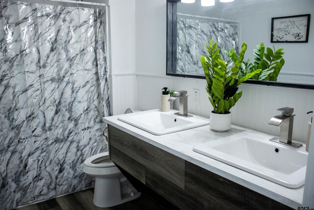 bathroom with toilet, a shower with curtain, vanity, and hardwood / wood-style flooring