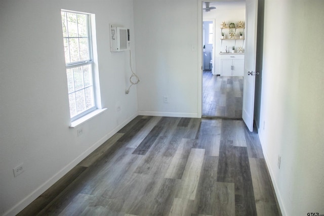 spare room with ceiling fan, a wealth of natural light, and dark hardwood / wood-style floors