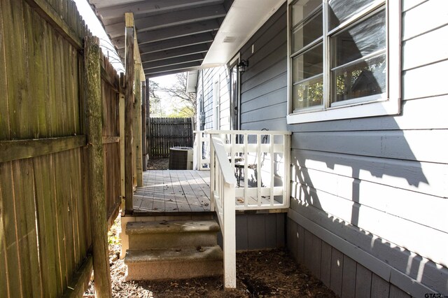 view of home's exterior with a wooden deck and central AC