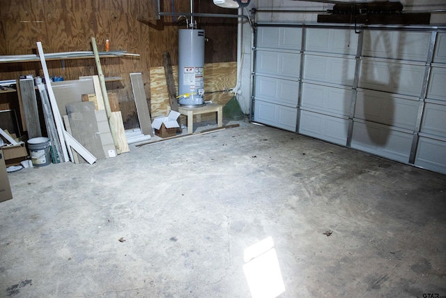 garage featuring water heater and wooden walls