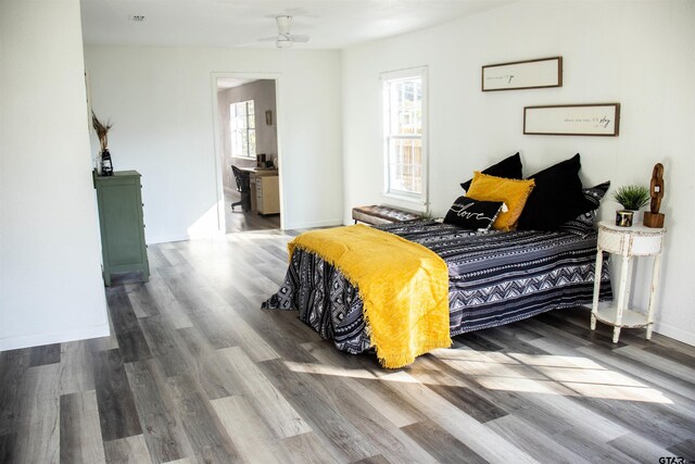 bedroom with multiple windows, wood-type flooring, and ceiling fan