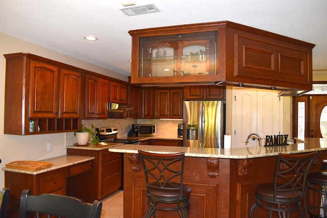 17387 Cherokee Trl, Flint, TX 75762 - kitchen with appliances with stainless steel finishes, a kitchen bar, under cabinet range hood, decorative backsplash, and recessed lighting