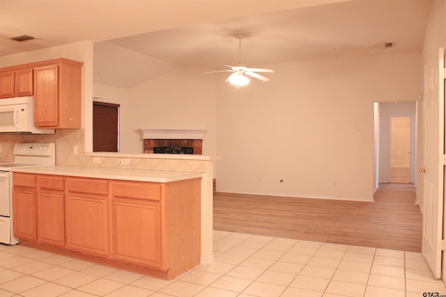 kitchen with light tile patterned flooring, backsplash, ceiling fan, kitchen peninsula, and white appliances