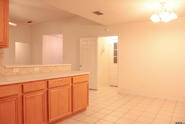 kitchen featuring tasteful backsplash, light tile patterned floors, and a chandelier