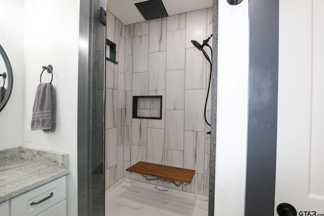 bathroom featuring vanity and tiled shower
