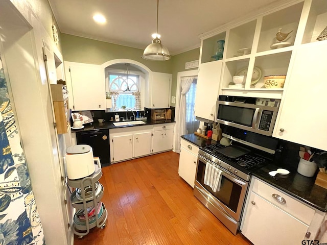 kitchen featuring appliances with stainless steel finishes, white cabinetry, sink, light hardwood / wood-style flooring, and crown molding