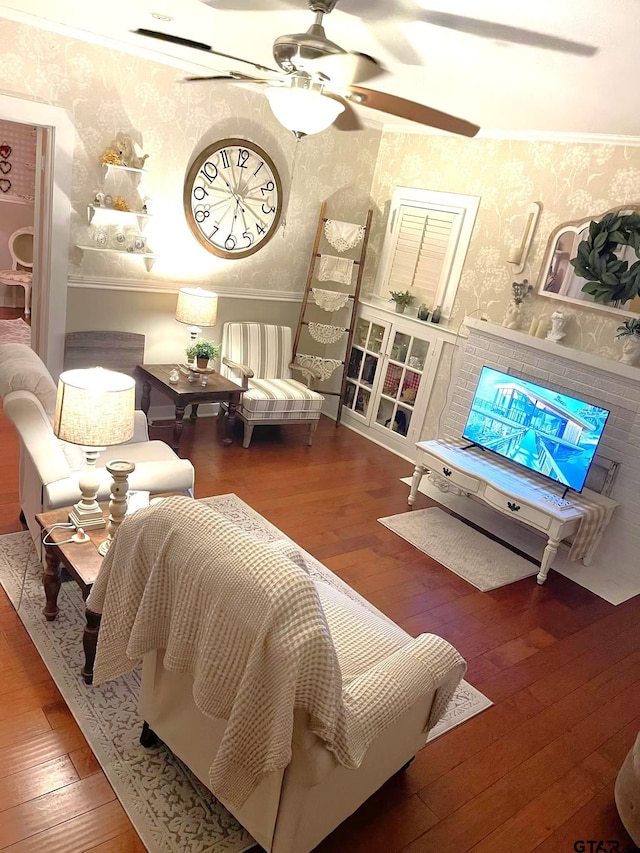 living area featuring ceiling fan, ornamental molding, and wood-type flooring