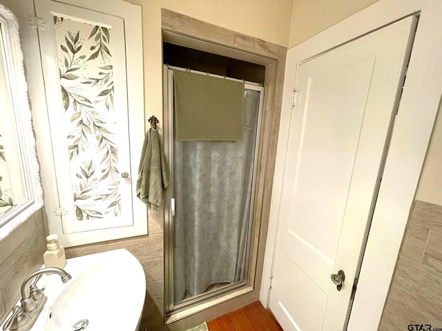 bathroom featuring hardwood / wood-style flooring, sink, and walk in shower