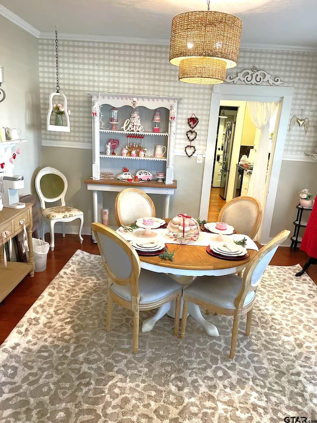 dining area featuring hardwood / wood-style flooring and ornamental molding