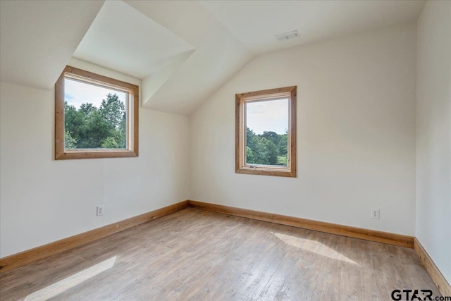 bonus room with wood-type flooring, vaulted ceiling, and plenty of natural light