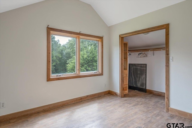 unfurnished bedroom featuring a closet, light hardwood / wood-style flooring, and vaulted ceiling