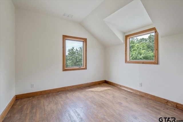 additional living space featuring hardwood / wood-style flooring and vaulted ceiling