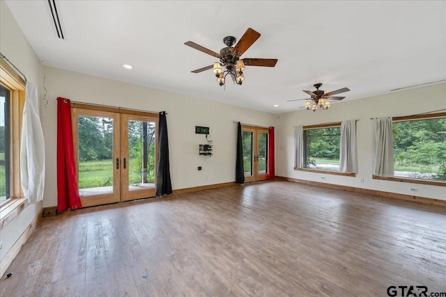 empty room with a wealth of natural light, ceiling fan, french doors, and hardwood / wood-style flooring