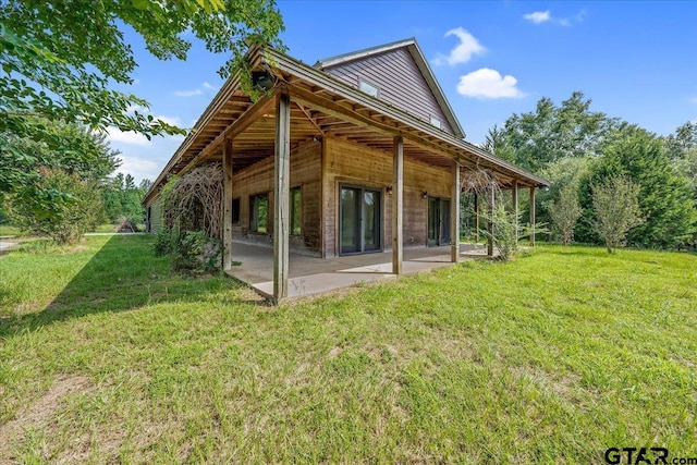 rear view of property featuring a yard and a patio area