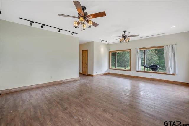 empty room featuring track lighting, wood-type flooring, and ceiling fan