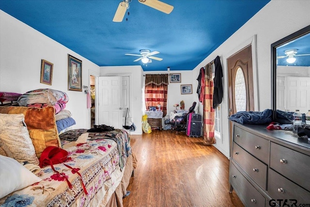 bedroom with ceiling fan, a textured ceiling, and wood finished floors