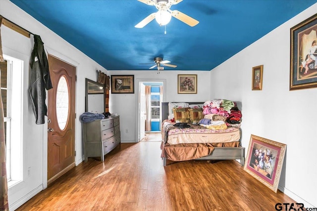 bedroom featuring ceiling fan, baseboards, and wood finished floors