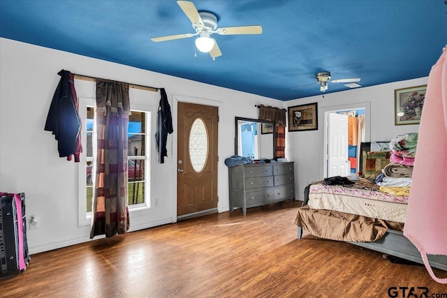 bedroom featuring wood finished floors, a ceiling fan, and baseboards