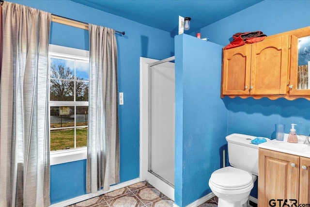 full bathroom featuring toilet, a shower stall, vanity, and baseboards