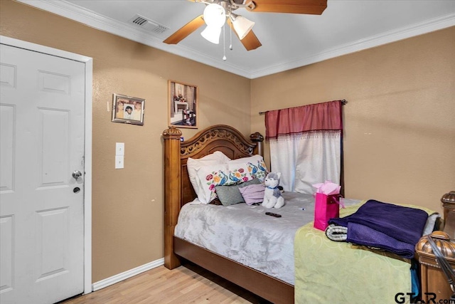 bedroom with a ceiling fan, visible vents, baseboards, ornamental molding, and light wood-type flooring