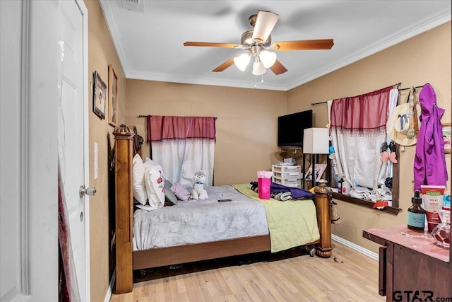 bedroom featuring baseboards, light wood-style floors, a ceiling fan, and crown molding