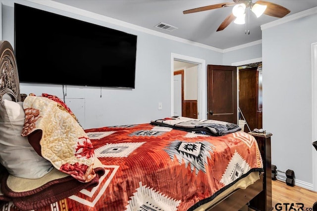 bedroom with a ceiling fan, visible vents, crown molding, and light wood-style flooring