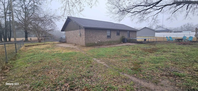 rear view of property with cooling unit and a lawn