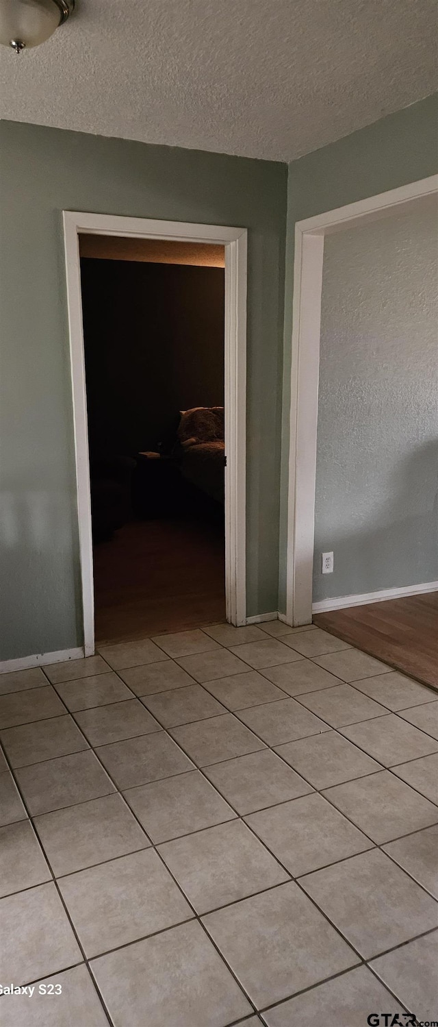 hallway with light tile patterned flooring and a textured ceiling