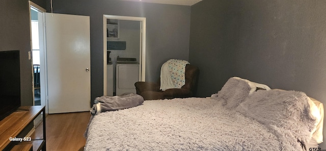 bedroom with hardwood / wood-style flooring and independent washer and dryer