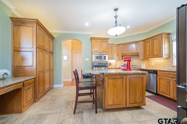 kitchen featuring custom exhaust hood, tasteful backsplash, arched walkways, appliances with stainless steel finishes, and light stone countertops