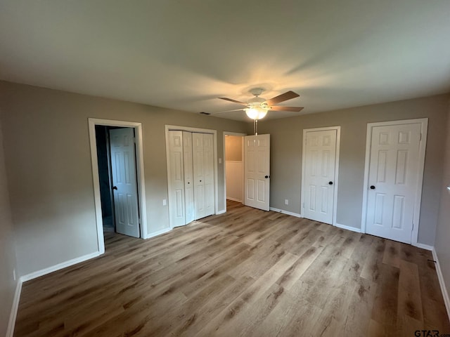 625 Northcrest Dr, Tyler, TX 75702 - unfurnished bedroom with two closets, wood finished floors, and ceiling fan